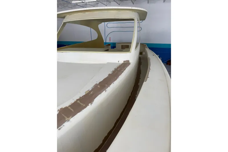 Slide: The Image of 2025 Xcelerator Walk Around boat under construction in a workshop. - 3