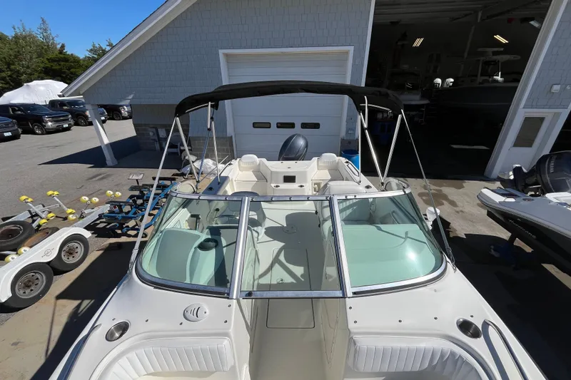 Slide: The Image of 2006 Hydra-Sports Lightning 202 DC boat with canopy, parked near a garage. - 14