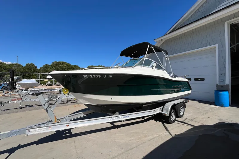Slide: The Image of 2006 Hydra-Sports Lightning 202 DC boat on trailer, parked outside a garage under clear blue sky. - 2