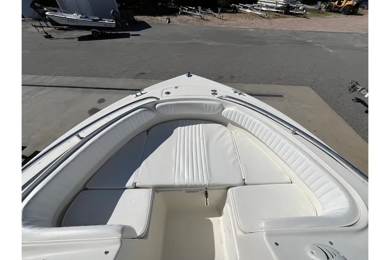Slide: The Image of 2006 Hydra-Sports Lightning 202 DC boat with white cushioned seating, docked outdoors. - 24