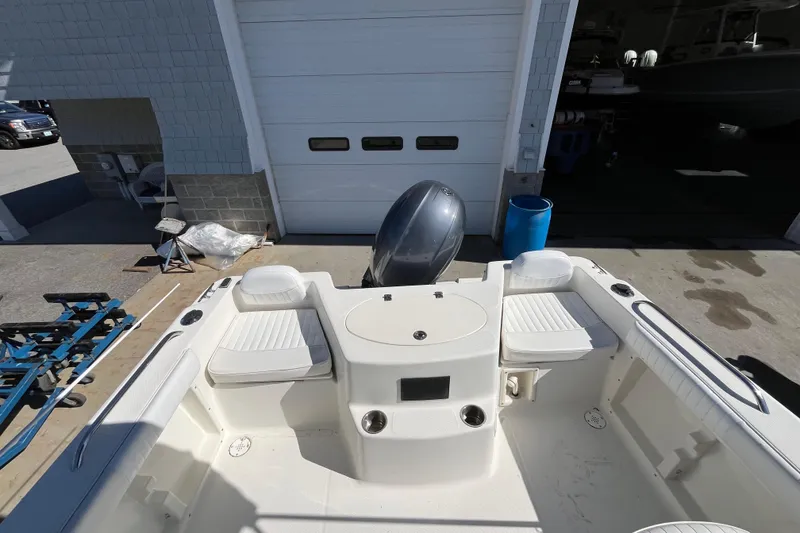 Slide: The Image of 2006 Hydra-Sports Lightning 202 DC boat interior with seating and motor, parked near a garage. - 27
