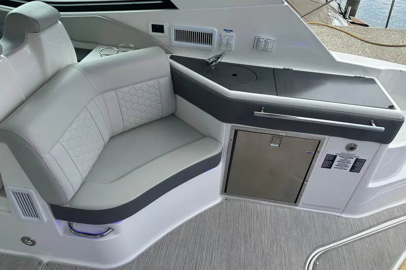 Slide: The Image of 2021 Sea Ray Sundancer 320 Coupe Outboard interior with seating and kitchenette area. - 15