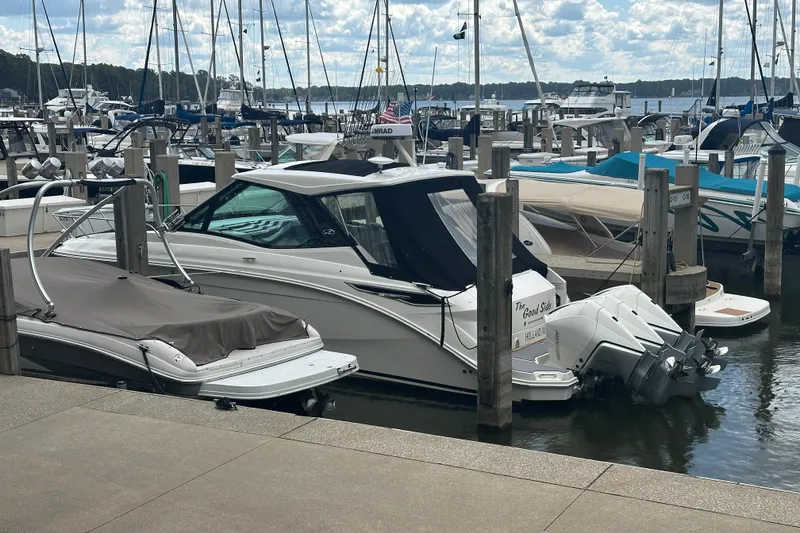 Slide: The Image of 2021 Sea Ray Sundancer 320 Coupe Outboard docked at a marina with other boats. - 2