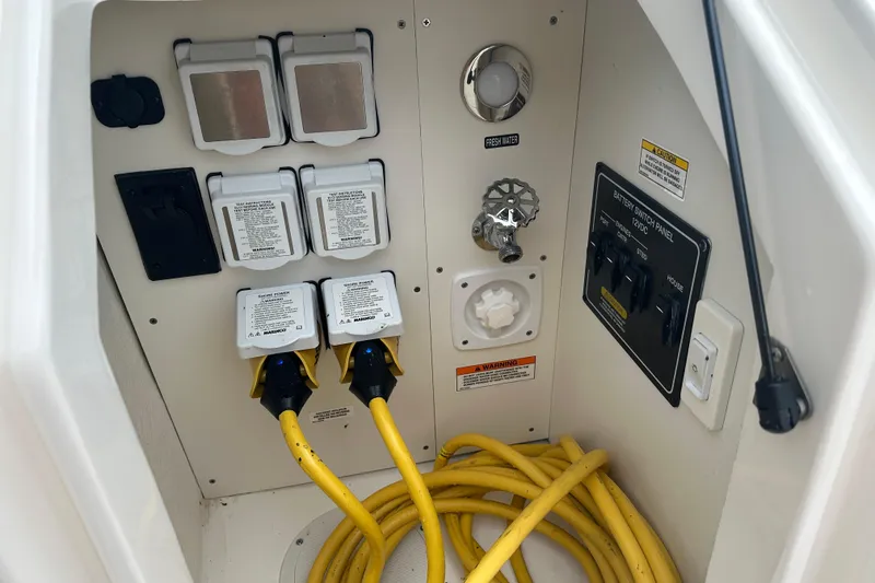 Slide: The Image of 2021 Sea Ray Sundancer 320 Coupe Outboard electrical panel with yellow power cords. - 32