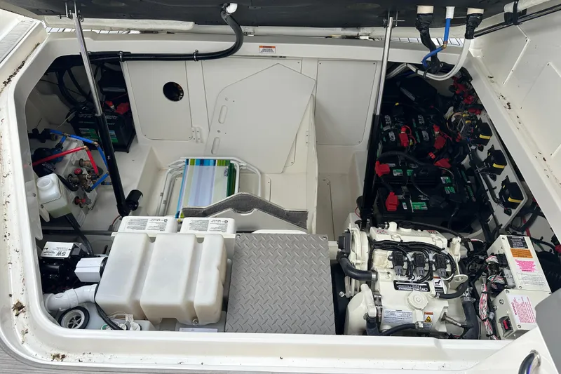 Slide: The Image of Engine compartment of 2021 Sea Ray Sundancer 320 Coupe Outboard, showcasing batteries and equipment. - 36