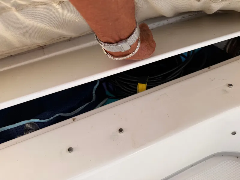 Slide: The Image of 2002 Bayliner 3488 Motoryacht storage compartment with coiled cables and hand opening hatch. - 29