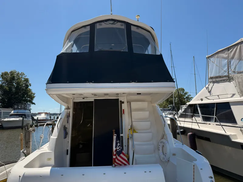 Slide: The Image of 2002 Bayliner 3488 Motoryacht docked at marina, rear view with American flag. - 4