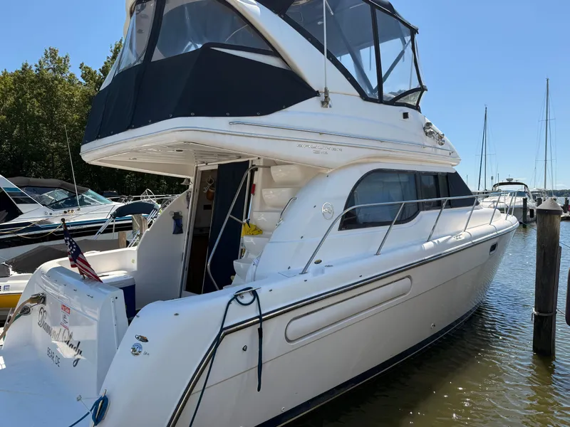 Slide: The Image of 2002 Bayliner 3488 Motoryacht docked at marina, featuring sleek design and spacious deck. - 7