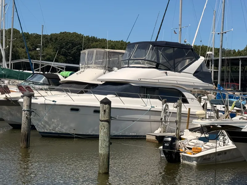Slide: The Image of 2002 Bayliner 3488 Motoryacht docked at marina, surrounded by other boats. - 8