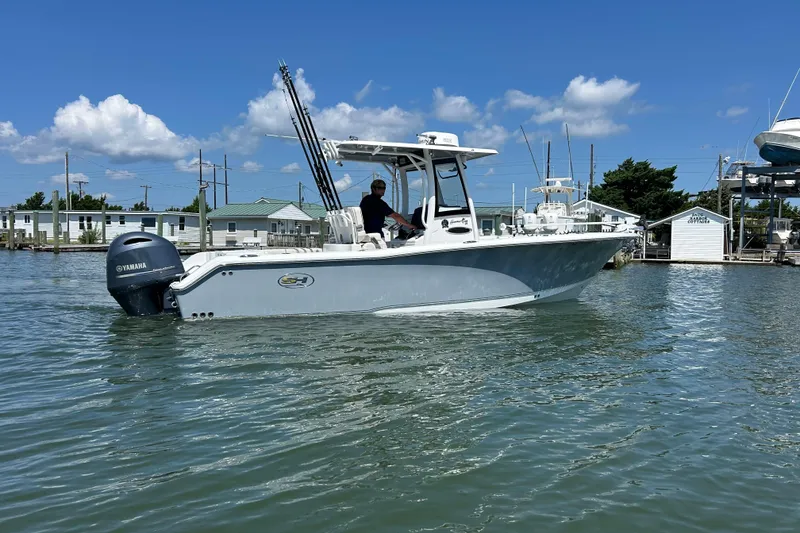 Slide: The Image of 2021 Sea Hunt Gamefish 25 boat on water, featuring Yamaha engine, clear blue sky. - 1