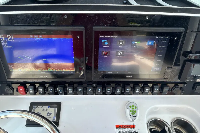 Slide: The Image of 2021 Sea Hunt Gamefish 25 dashboard with dual Garmin displays and control switches. - 27