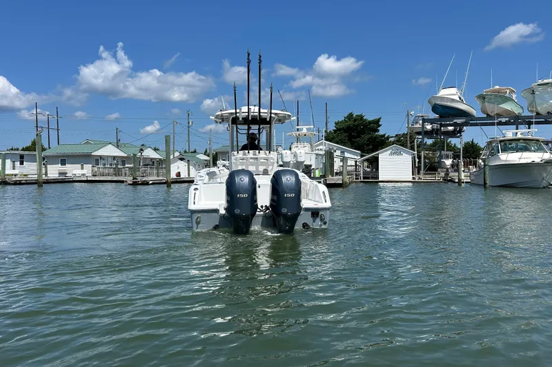 Slide: The Image of 2021 Sea Hunt Gamefish 25 boat with dual engines docked in a marina under blue skies. - 3