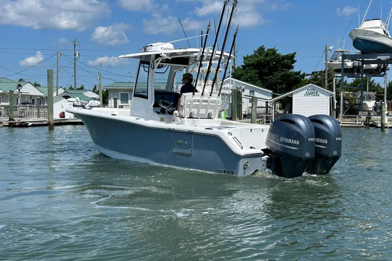 Slide: The Image of 2021 Sea Hunt Gamefish 25 boat with dual Yamaha engines in a marina setting. - 4