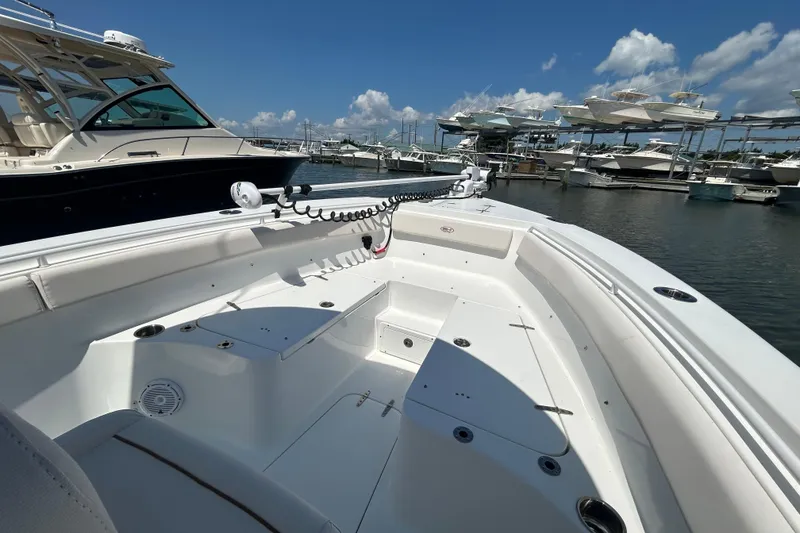 Slide: The Image of 2021 Sea Hunt Gamefish 25 boat docked at marina, clear sky, multiple boats in background. - 40