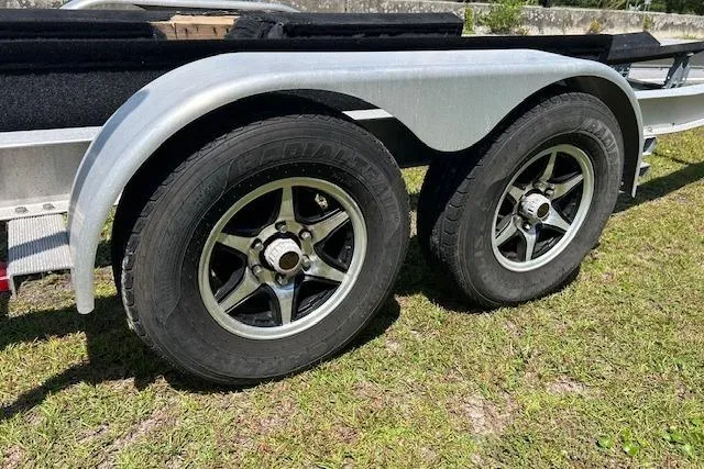 Slide: The Image of Trailer wheels for 2021 Sea Hunt Gamefish 25 on grassy surface. - 43