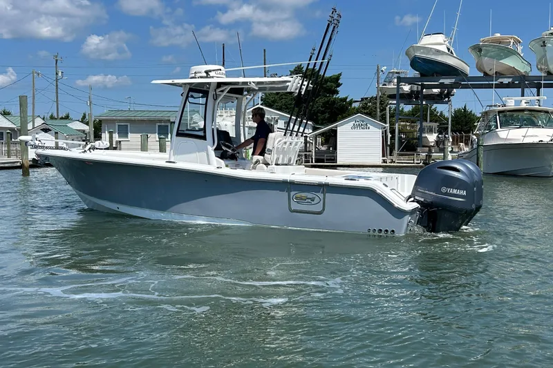 Slide: The Image of 2021 Sea Hunt Gamefish 25 boat with Yamaha engine in a marina setting. - 5