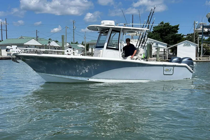 Slide: The Image of 2021 Sea Hunt Gamefish 25 boat on water, clear sky, fishing rods visible. - 6