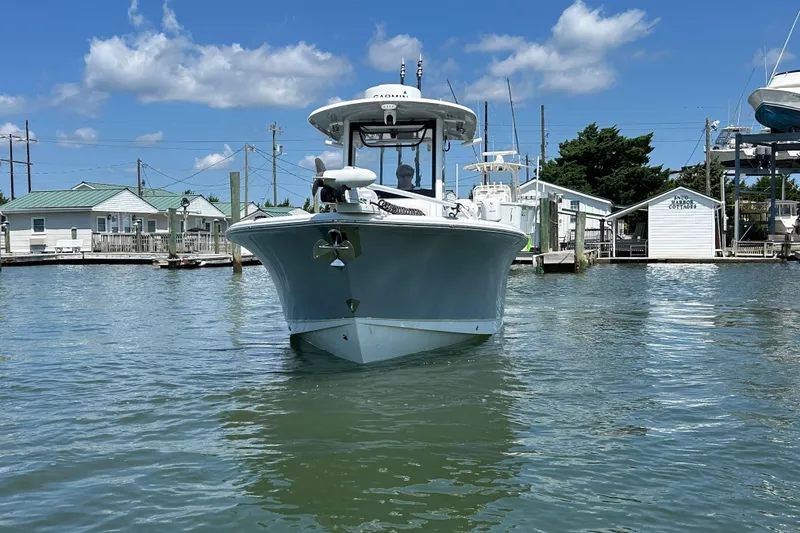 Slide: The Image of 2021 Sea Hunt Gamefish 25 boat docked in a marina under a clear blue sky. - 7