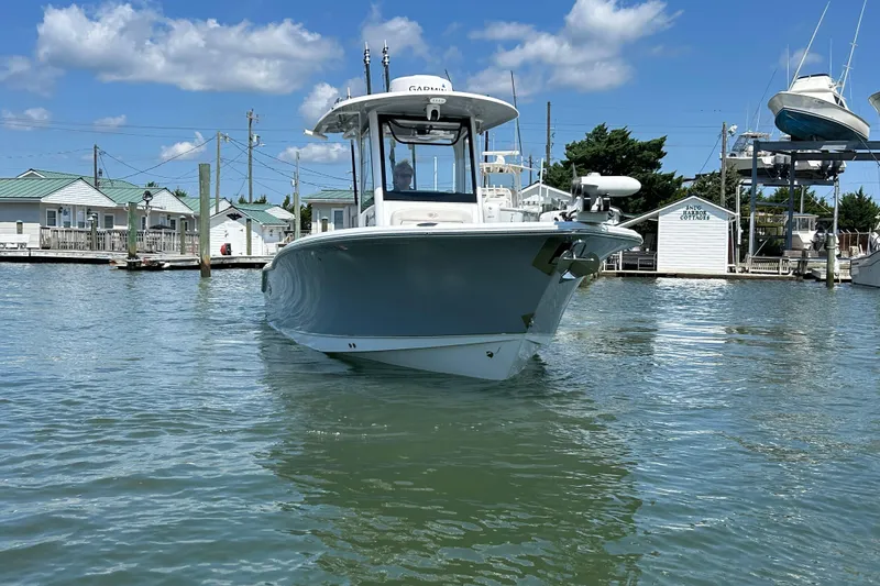 Slide: The Image of 2021 Sea Hunt Gamefish 25 boat docked in a marina under a clear blue sky. - 8
