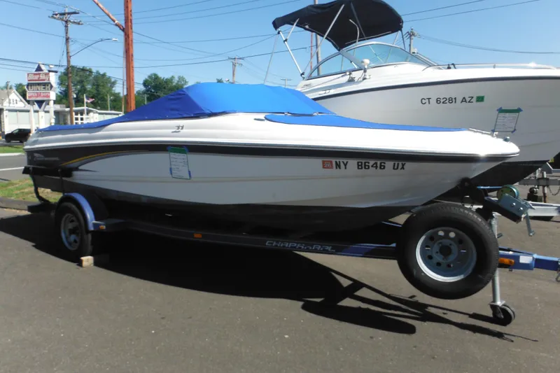The Image of 2003 Chaparral 180 SS boat with blue cover on trailer, parked outdoors. - 0