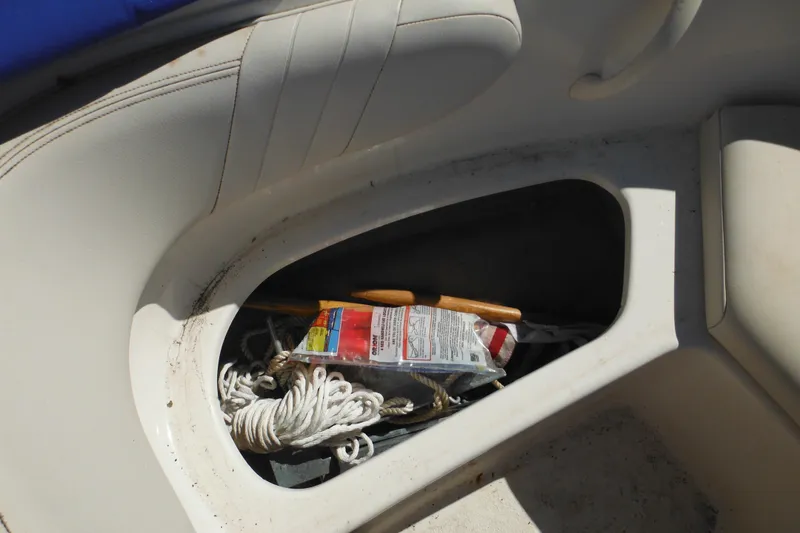 Slide: The Image of Storage compartment in a 2003 Chaparral 180 SS boat with rope and safety equipment. - 16