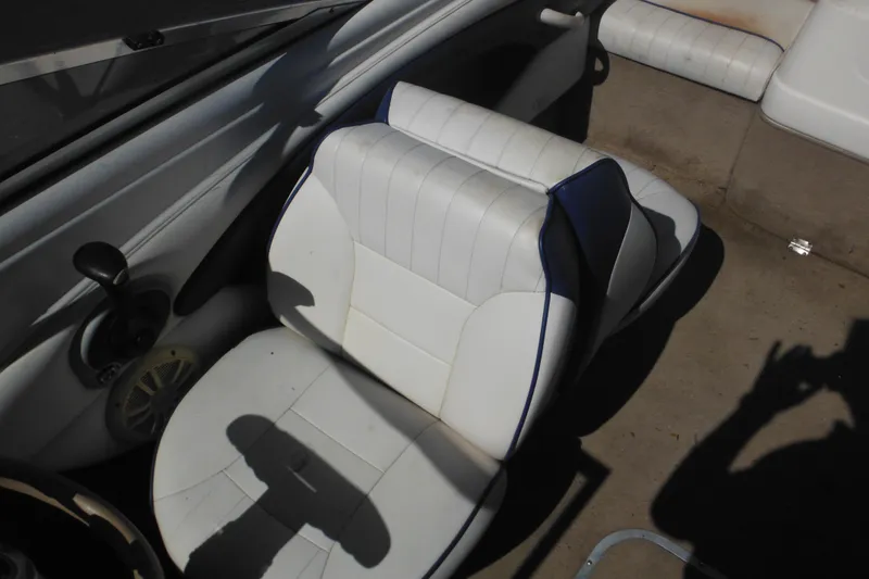 Slide: The Image of 2003 Chaparral 180 SS boat interior with white seating and steering controls. - 26