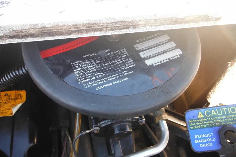 Slide: The Image of Engine compartment of a 2003 Chaparral 180 SS boat, showing specifications and caution labels. - 37