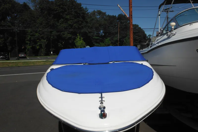 Slide: The Image of 2003 Chaparral 180 SS boat with blue cover, parked outdoors. - 6