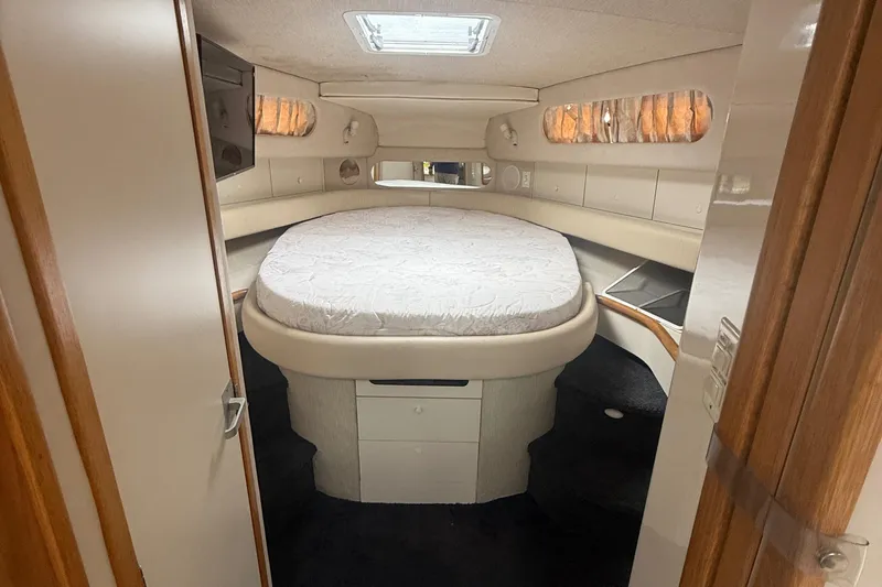 Slide: The Image of Interior cabin of 1996 Sea Ray 450 Sundancer yacht with cozy bed and wooden accents. - 12