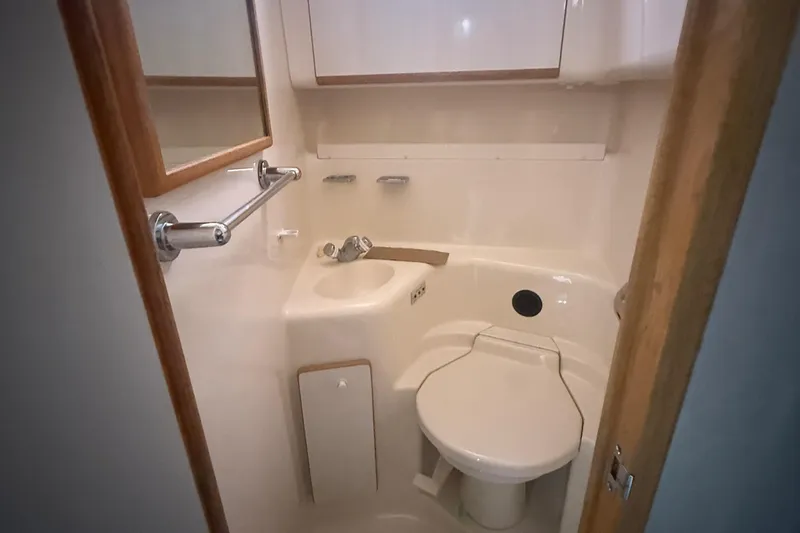 Slide: The Image of Compact bathroom in 1996 Sea Ray 450 Sundancer yacht, featuring toilet and sink. - 16