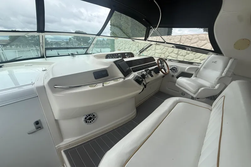 Slide: The Image of 1996 Sea Ray 450 Sundancer helm with white seating and modern controls. - 5