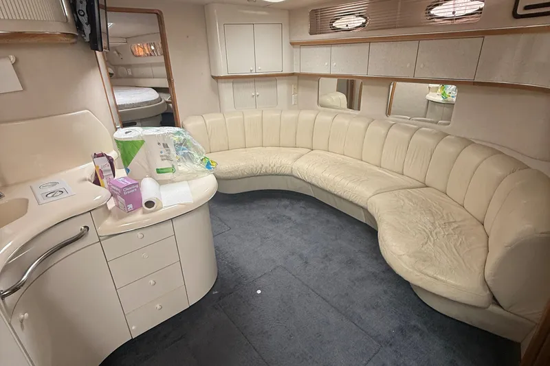 Slide: The Image of Interior of 1996 Sea Ray 450 Sundancer yacht with curved seating and kitchenette. - 9
