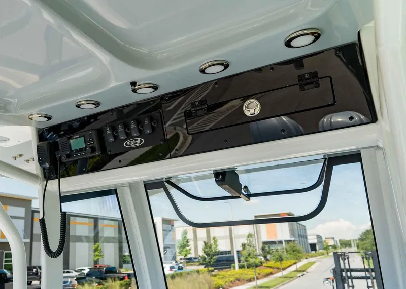 Slide: The Image of 2025 Sea Hunt Ultra 305 SE boat dashboard with controls and radio. - 6