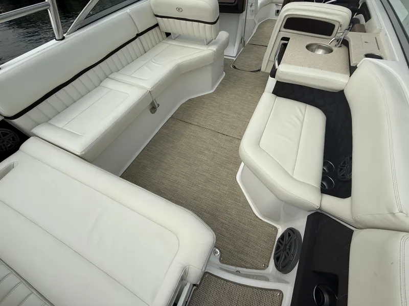 Slide: The Image of Interior of a 2016 Cobalt A28 boat with white leather seating and a small sink. - 14