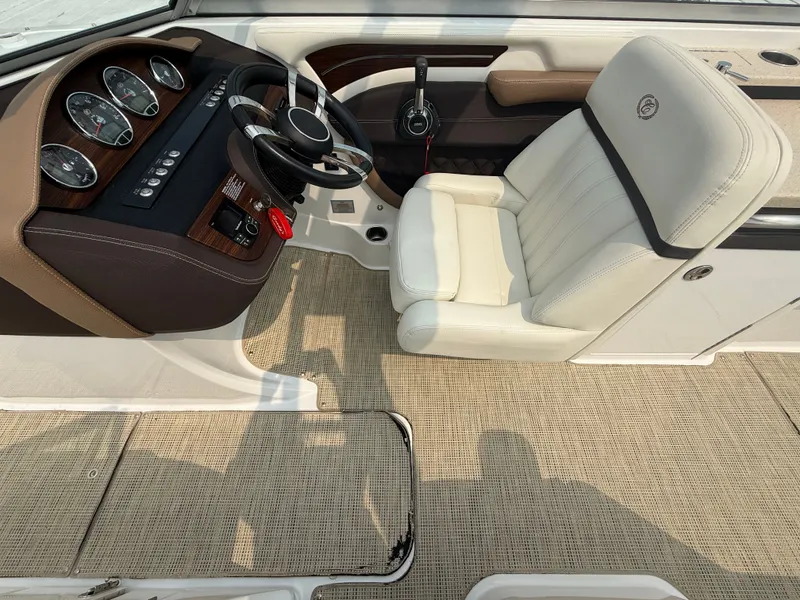 Slide: The Image of Interior of 2016 Cobalt A28 boat with steering wheel and beige captain's chair. - 19