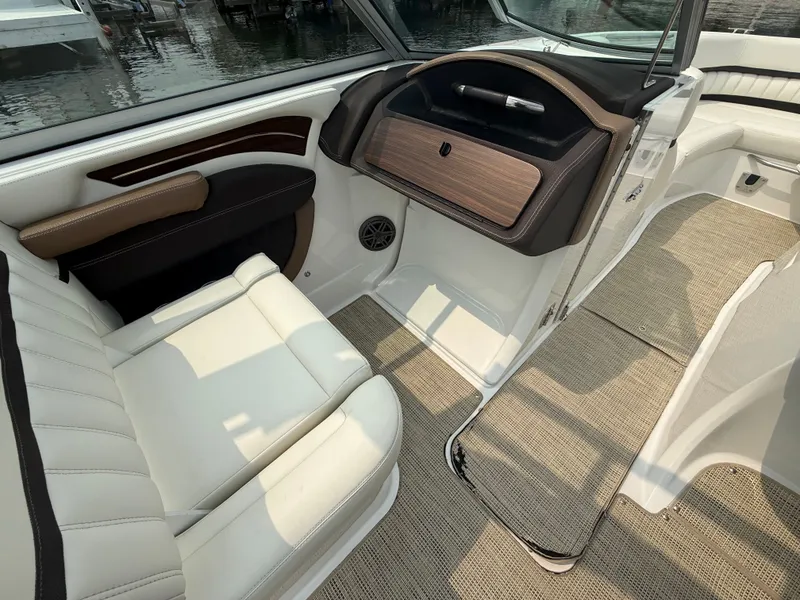 Slide: The Image of Interior of a 2016 Cobalt A28 boat with white seating and wood accents. - 23