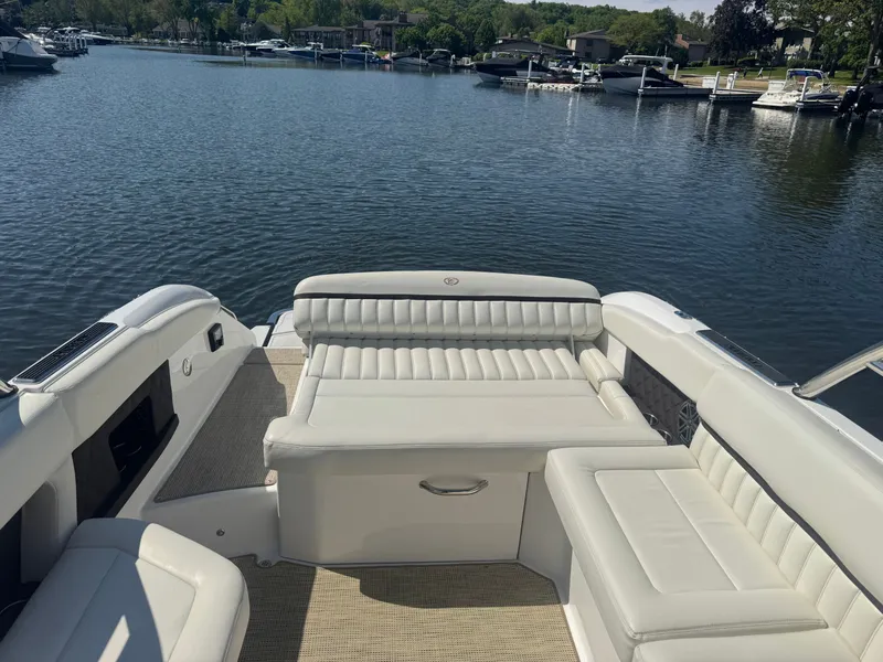 Slide: The Image of 2016 Cobalt A28 boat with white seating, docked on a serene lake. - 3