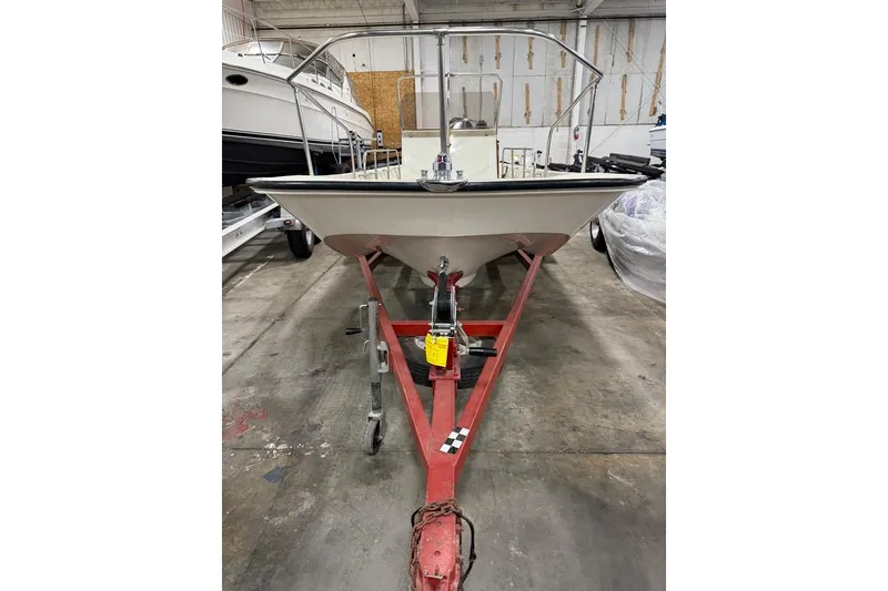 The Image of 1982 Boston Whaler 17 Montauk on red trailer in indoor storage facility. - 1