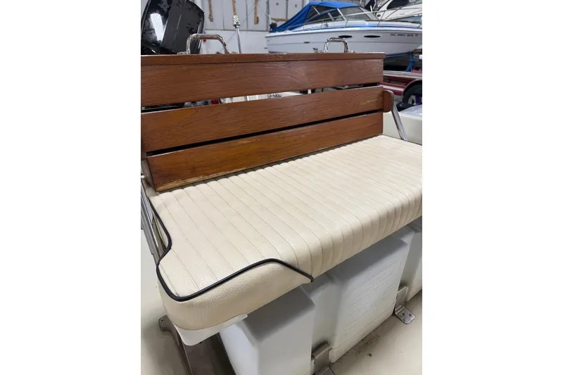 Slide: The Image of 1982 Boston Whaler 17 Montauk boat seat with wooden backrest and cushioned base. - 11
