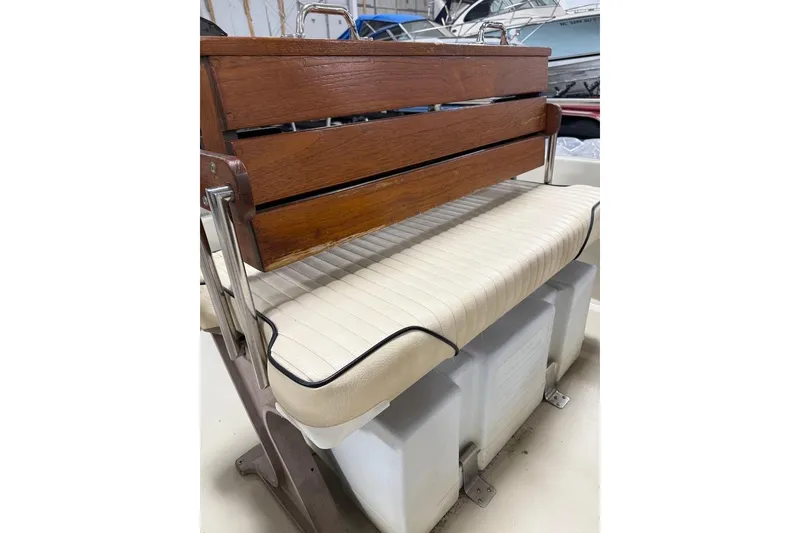 Slide: The Image of 1982 Boston Whaler 17 Montauk boat seat with wooden backrest and cushioned seating. - 9