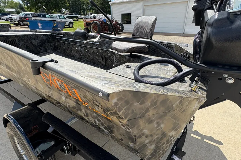 Slide: The Image of 2026 Excel Eclipse boat with camouflage design on a trailer, parked outdoors. - 21