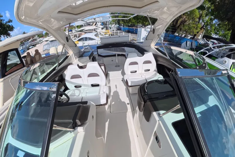 Slide: The Image of 2017 Sea Ray SLX 350 boat interior with seating and helm, docked outdoors. - 19