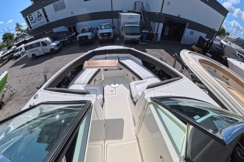 Slide: The Image of 2017 Sea Ray SLX 350 boat interior with seating and table, parked at a marina. - 21