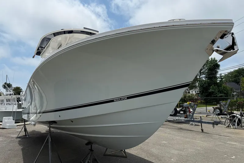 Slide: The Image of 2026 Regulator 31 boat on stands, viewed from the bow, outdoors. - 18