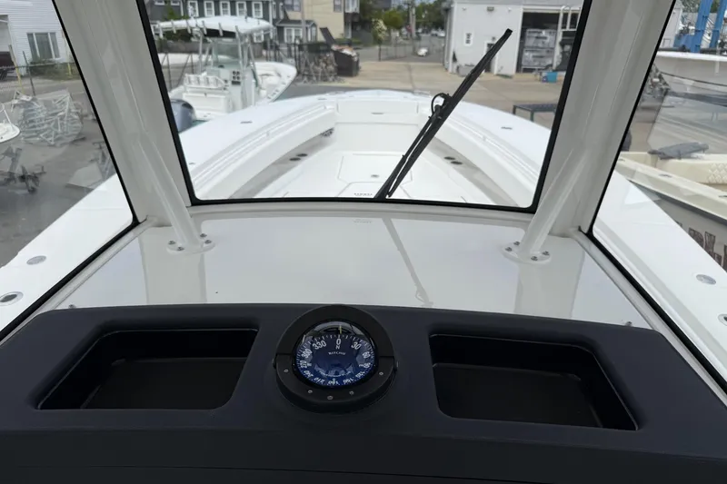 Slide: The Image of 2026 Regulator 31 boat dashboard with compass, docked in a marina setting. - 19