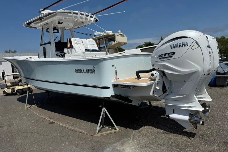 Slide: The Image of 2026 Regulator 31 boat with Yamaha XTO Offshore engine, displayed on stands outdoors. - 27