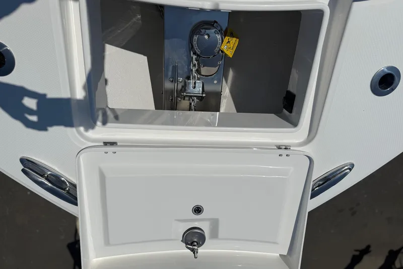 Slide: The Image of 2026 Regulator 31 boat anchor compartment with open hatch and visible chain mechanism. - 32