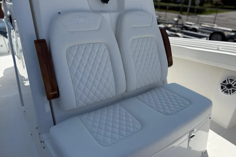 Slide: The Image of 2026 Regulator 31 boat with luxurious white quilted seating and wooden armrests. - 36