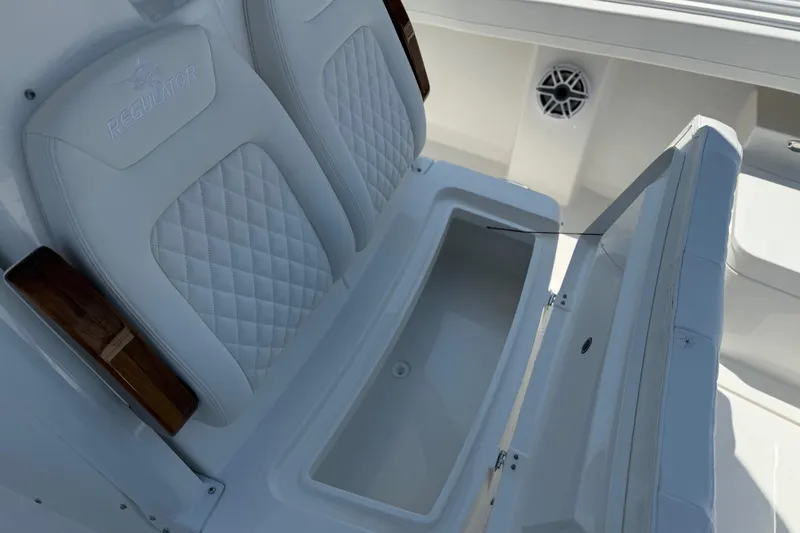 Slide: The Image of 2026 Regulator 31 boat with open storage compartment and cushioned seating. - 37