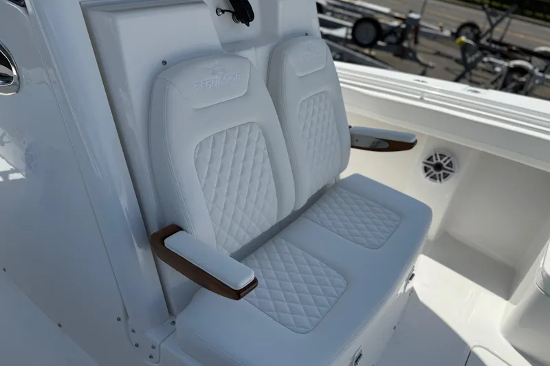 Slide: The Image of Luxury seating on 2026 Regulator 31 boat with quilted white upholstery and wooden armrests. - 40